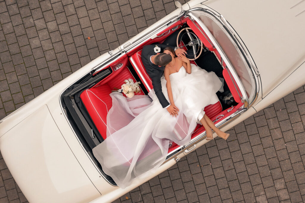 Drohnenbild, Brautpaar im Oldtimer, Francesco Calarota Hochzeitsfotograf Stuttgart Hochzeitsfotograf Esslingen Hochzeitsfotograf Ludwigsburg Hochzeitsfotograf Reutlingen Hochzeitsfotograf Heilbronn Hochzeitsfotograf Calw Hochzeitsfotograf Waiblingen Hochzeitsfotograf Rems Murr